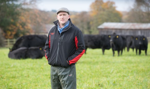 Strategic Farmer, Ian Norbury, in field with cows behind